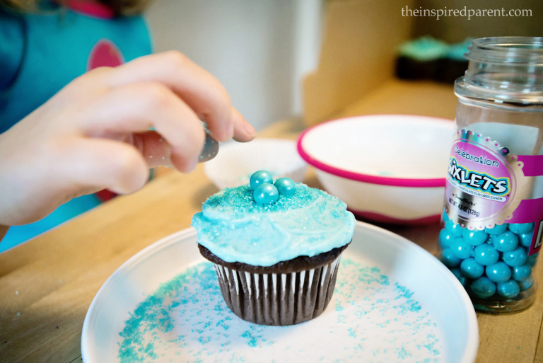 We made our favorite frosting, added a drop or two of food coloring to get the "Frozen" shade. The birthday girl was on sprinkle duty and she also added the blue candies on top. Such a fun way to get the little ones to help in the kitchen!